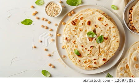 Chickpea flour flat bread on white plate with chickpeas nut decoration flat lay 126975885