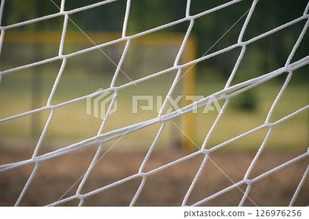 Close-Up of Soccer Net With Blurry Goalpost in Background Close-Up of Soccer Net With Blurry Goalpost in Background 126976256