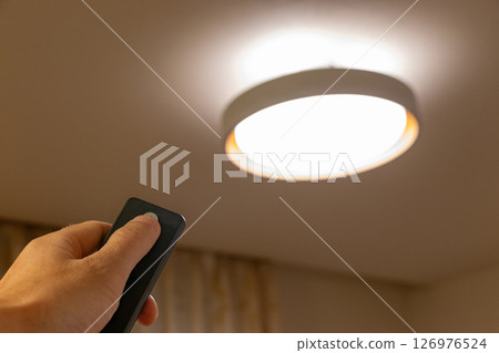 Turn on the lights in the room with a remote control Turn on the lights in the room with a remote control 126976524
