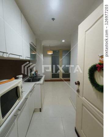 A pristine, white kitchen exudes sense of calm and cleanliness, offering welcoming atmosphere and promise of culinary creativity 126977203