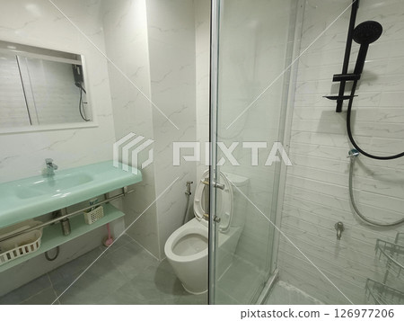 A pristine bathroom, bathed in clean, soft light, inspires sense of calm and relaxation with its simple, elegant fixtures for refreshing experience 126977206