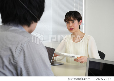 A woman consulting while looking at documents 126977242