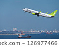 A Solaseed Air passenger plane ascends over Tokyo Bay after taking off from runway C at Haneda Airport. 126977466