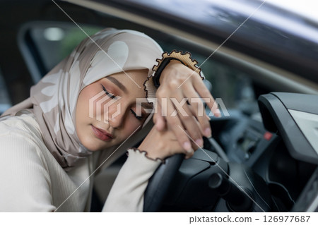 Muslim women sleep inside car on steering wheel. Feeling drowsy while driving. When you feel sleepy, you should stop driving to rest. Muslim women sleep inside car on steering wheel. Feeling drowsy while driving. When you feel sleepy, you should stop driving to rest. 126977687