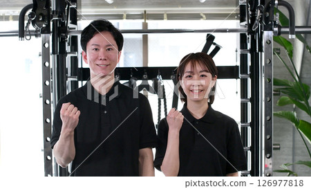 Asian men and women doing fist pumps at the gym 126977818