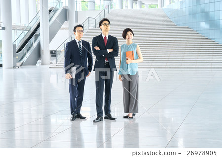 Business team standing side by side in an office lobby Business team standing side by side in an office lobby 126978905