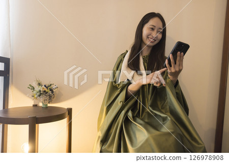 一位女士在艾蒿蒸汽浴時看著她的智慧型手機 126978908