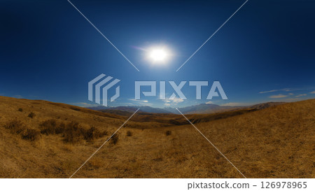 Dry, open landscape with rolling hills under a bright sun. Dry, open landscape with rolling hills under a bright sun. 126978965