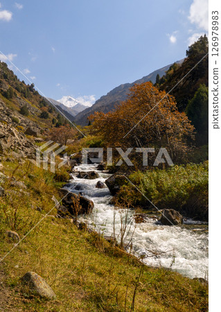 Mountain river flowing through a scenic gorge with a hiking trail along the bank. Mountain river flowing through a scenic gorge with a hiking trail along the bank. 126978983