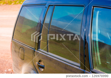 Dust-covered black car parked outdoors. 126978990