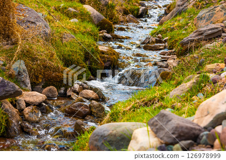 Clear stream flowing over mossy rocks. Clear stream flowing over mossy rocks. 126978999