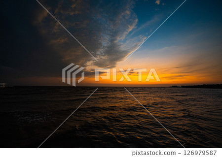 Picture of the atmosphere of the sea in the evening, the light and color of the sky are beautiful. Picture of the atmosphere of the sea in the evening, the light and color of the sky are beautiful. 126979587
