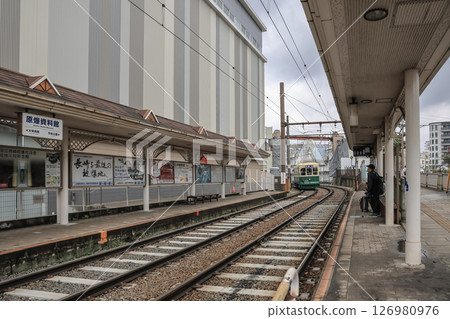 March 28 2025 Train Station with Rail Tracks and Waiting Commuters 126980976