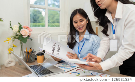 Financial Analysis and Teamwork. Women discussing a financial report in a bright office. Financial Analysis and Teamwork. Women discussing a financial report in a bright office. 126981524