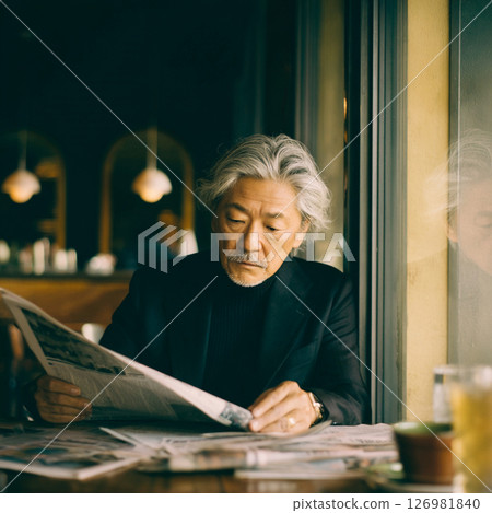 Senior man relaxing reading a newspaper in a cafe 126981840