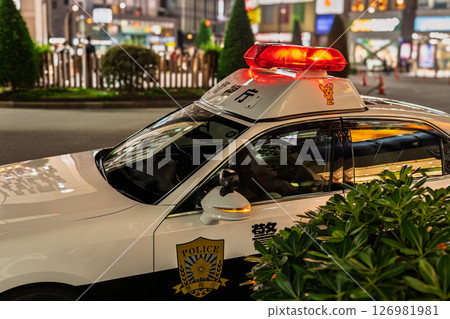 Police car with red lights on in downtown at night 126981981