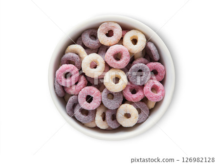 Top view bowl with various fruits circles and vitamins breakfast cereal on white.Macro. 126982128