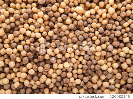 Mini peanut butter and chocolate puffs breakfast cereal textured macro shot.Top view. Mini peanut butter and chocolate puffs breakfast cereal textured macro shot.Top view. 126982146