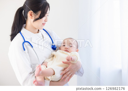 Young female doctor holding a baby Young female doctor holding a baby 126982176