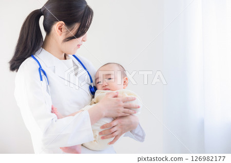 Young female doctor holding a baby 126982177
