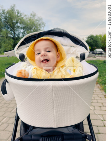 Smiling Baby in Yellow Hoodie in Stroller Smiling Baby in Yellow Hoodie in Stroller 126983001