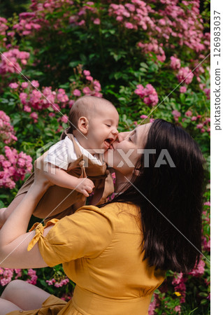 Joyful Mother and Baby in Blooming Garden 126983037