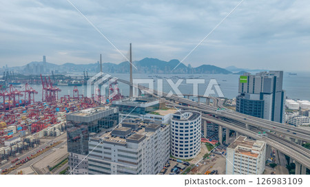 May 25 2025 Large Seaport with Stacked Containers and Cranes in Urban Area 126983109