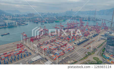 May 25 2025 Large Seaport with Stacked Containers and Cranes in Urban Area 126983114