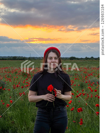 Young Woman in Poppy Field with Red Hat 126983184