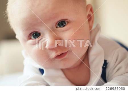 Four months old baby boy crawling on bed, detail on his head and face expression 126985060
