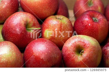 Bright red apples, with few wet drops, displayed on food market, closeup detail 126985073