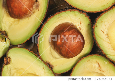 Avocado halves, with brown seed inside, closeup detail view from above Avocado halves, with brown seed inside, closeup detail view from above 126985074