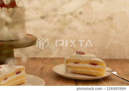 A whole strawberry shortcake on a cake stand and a slice of shortcake on a white plate A whole strawberry shortcake on a cake stand and a slice of shortcake on a white plate 126985984