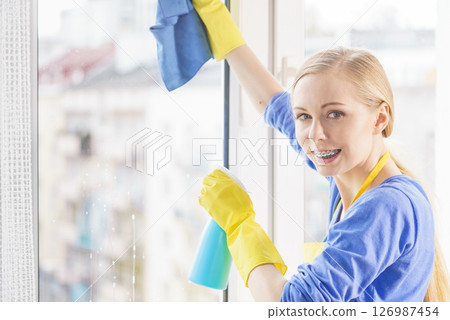 Woman cleaning window at home 126987454