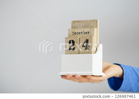Hand holding calendar with christmas date Hand holding calendar with christmas date 126987461