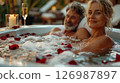 A man and a woman are relaxing in a jacuzzi. 126987897