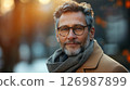 Close-up portrait of a man with a beard wearing stylish glasses. 126987899