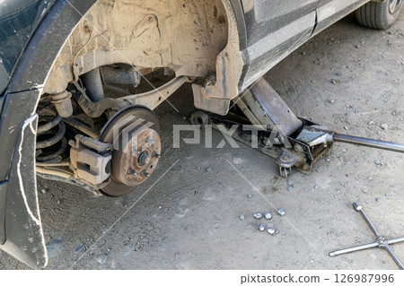 Car brake disc, removed wheel. Trolley jack lifts car. Tire fitting process 126987996