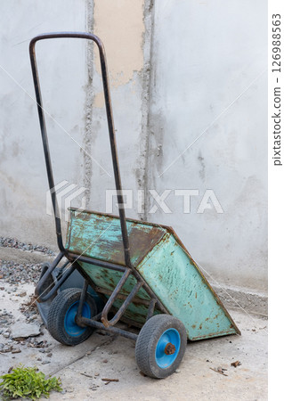 A construction cart leaning against the wall of a building A construction cart leaning against the wall of a building 126988563