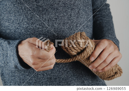 man pulling rope from a tangled coil 126989055