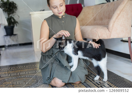 Pretty lovely smiling child girl sitting with cat pet on floor at home Pretty lovely smiling child girl sitting with cat pet on floor at home 126989552