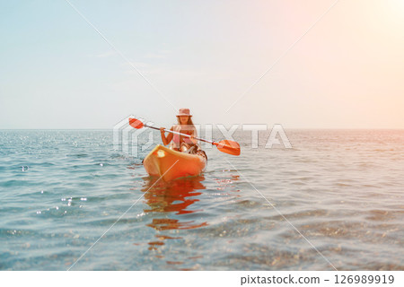 Kayak sea woman. Happy attractive woman with long hair in red swimsuit, swimming on kayak. Summer holiday vacation and travel concept. Kayak sea woman. Happy attractive woman with long hair in red swimsuit, swimming on kayak. Summer holiday vacation and travel concept. 126989919