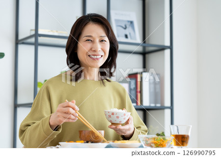 Middle-aged woman eating Middle-aged woman eating 126990795