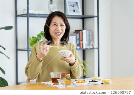 Middle-aged woman eating Middle-aged woman eating 126990797