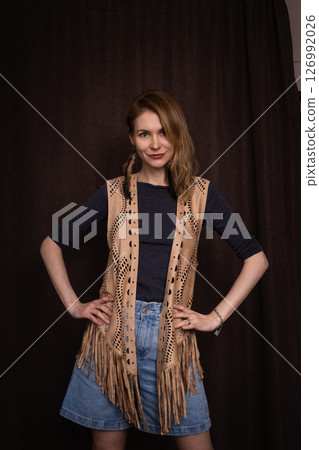 A young girl poses in a boho style suede vest. A young girl poses in a boho style suede vest. 126992026