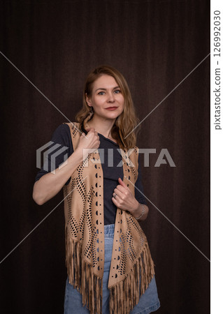 A young girl poses in a boho style suede vest. 126992030