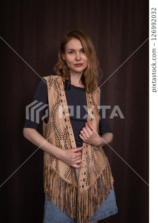 A young girl poses in a boho style suede vest. 126992032