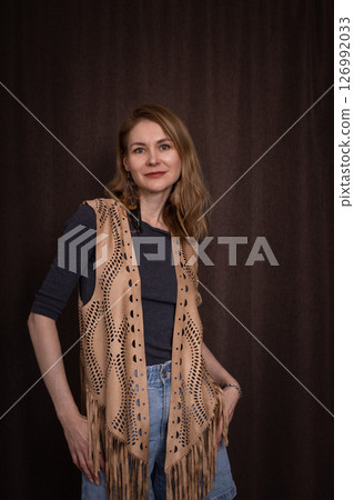 A young girl poses in a boho style suede vest. 126992033