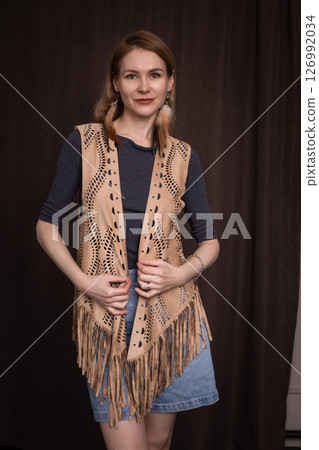 A young girl poses in a boho style suede vest. 126992034