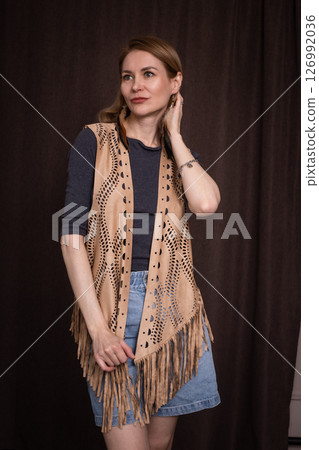 A young girl poses in a boho style suede vest. A young girl poses in a boho style suede vest. 126992036